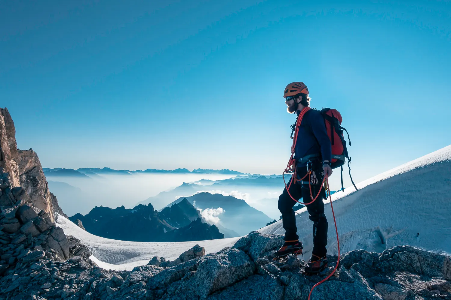 Man with a beard standing with mountains in the background