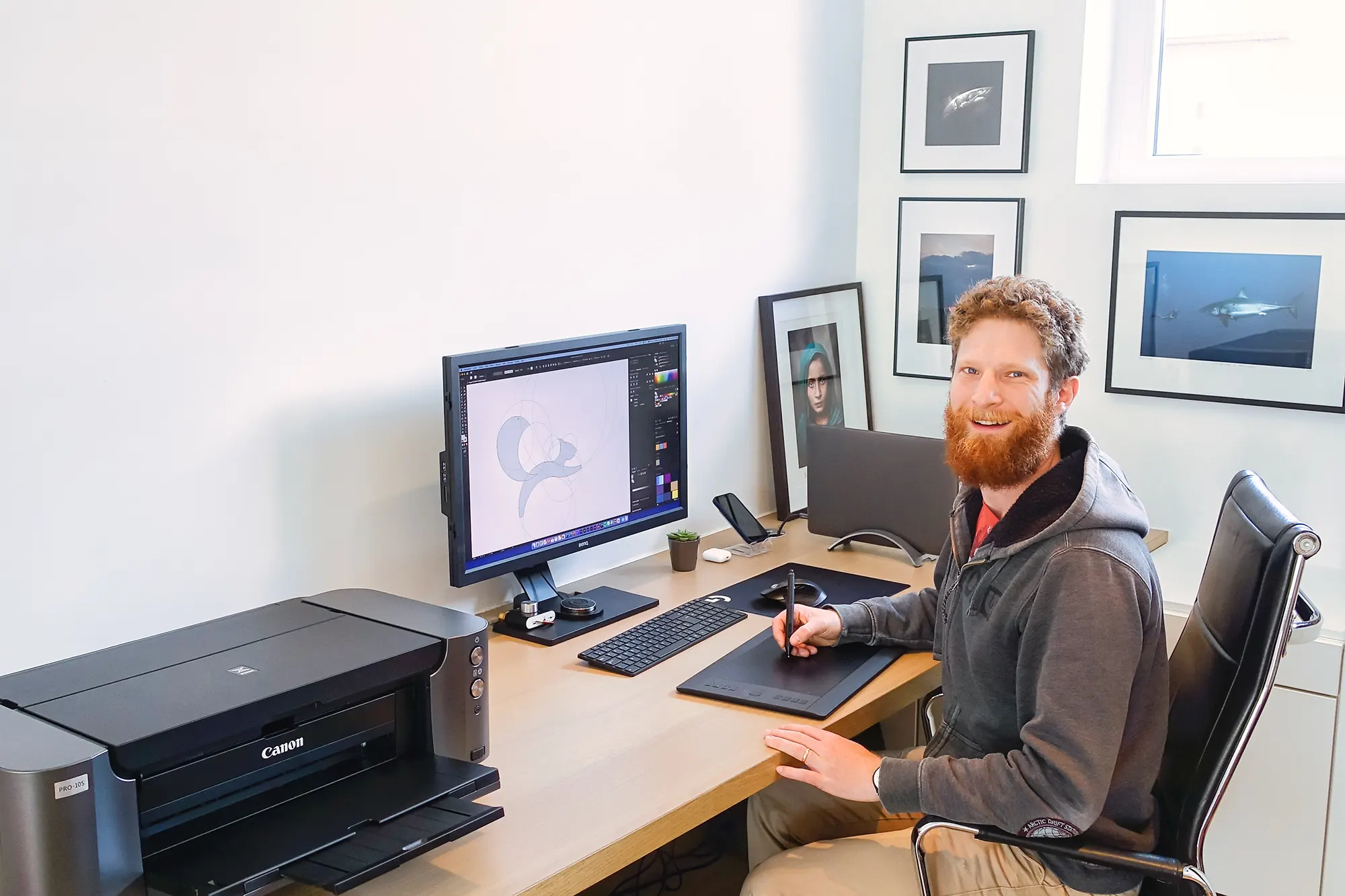 Man with a beard behing a computer screen