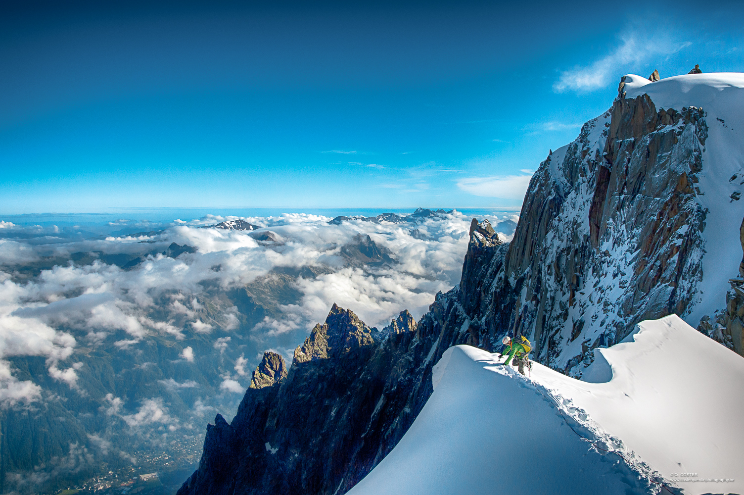 Mountaineer on a ridge with blue sky