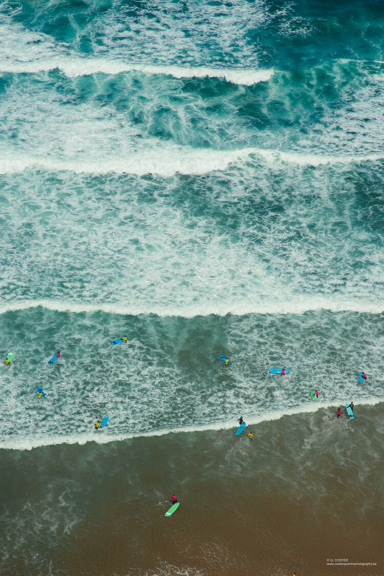 Aerial view of a surf course with colorful surfers